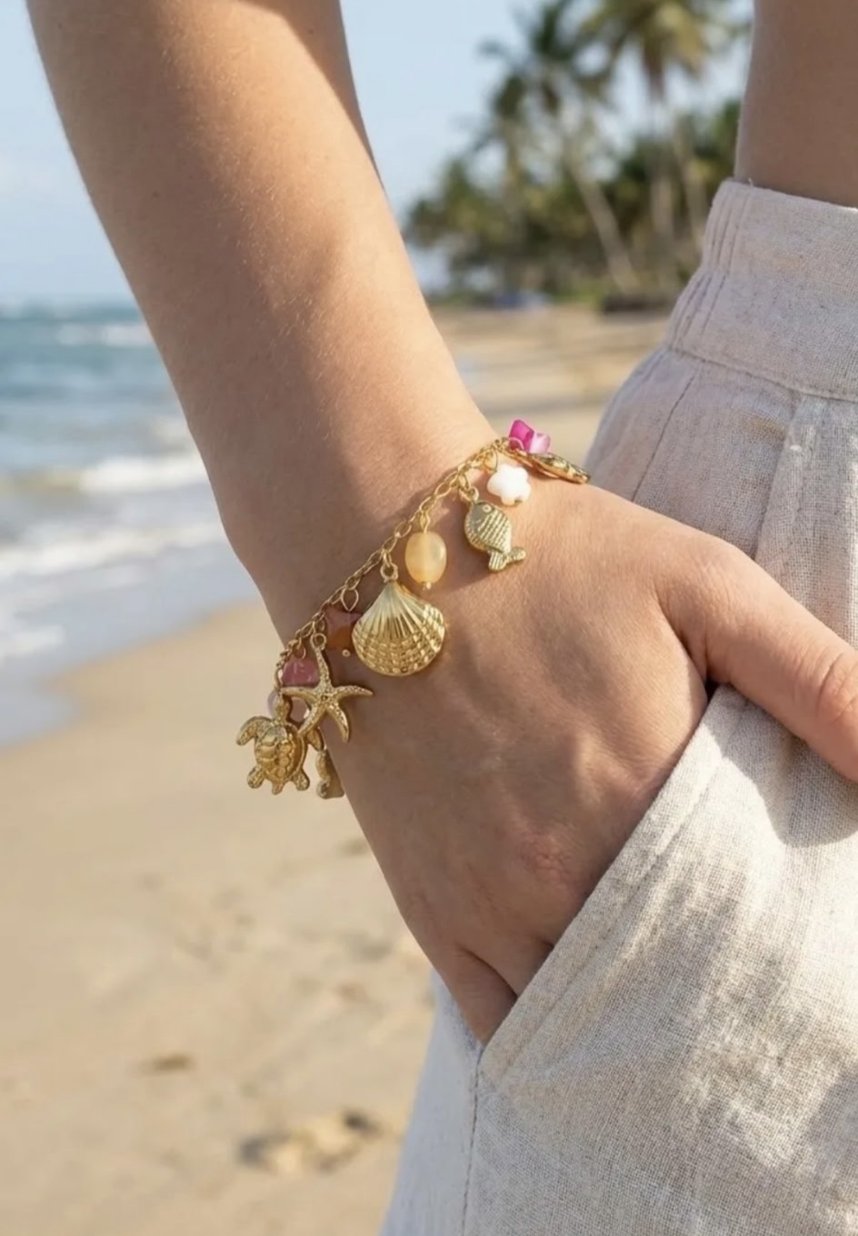 Bracelet doré breloques marines porté au poignet